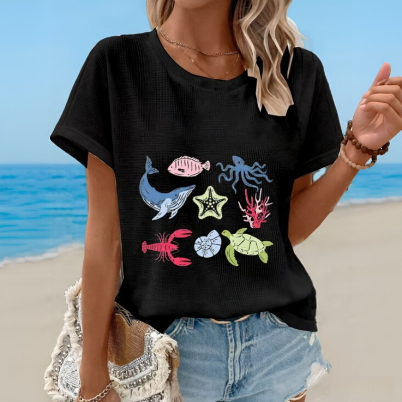 Woman in beachwear with marine-themed shirt.