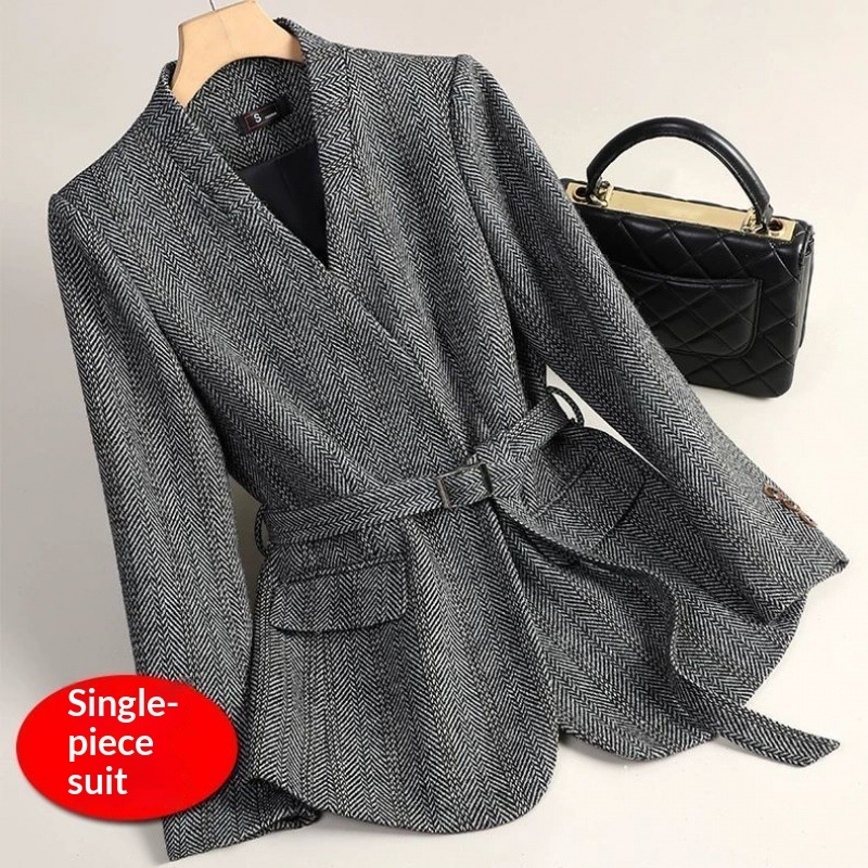 Gray herringbone suit with black handbag.