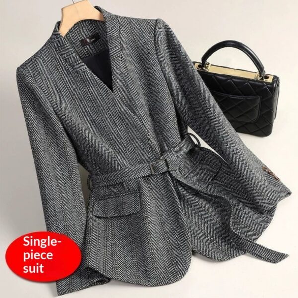 Gray herringbone suit with black handbag.