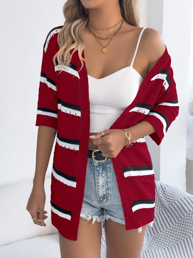 Woman in red striped cardigan and denim shorts.
