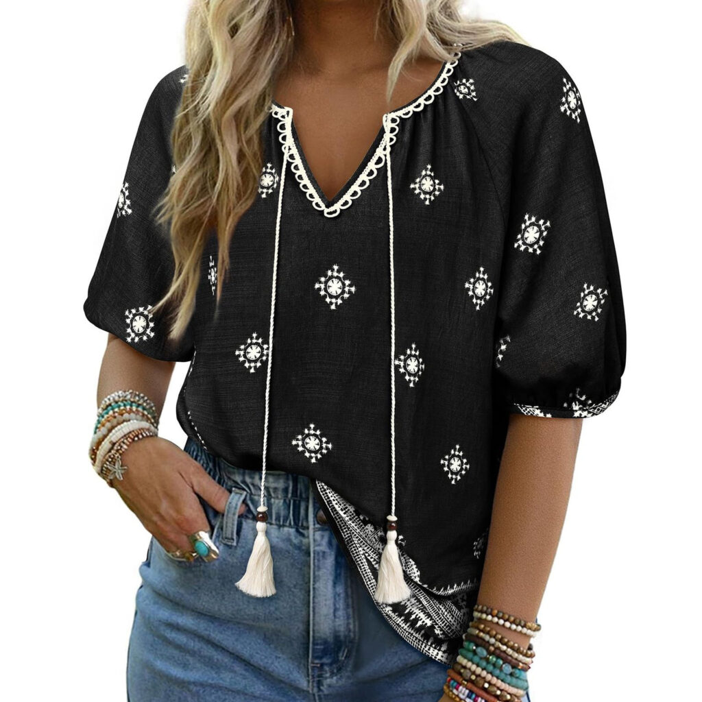 Woman in black patterned blouse and jeans.