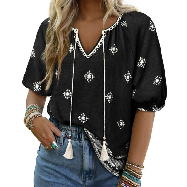 Woman in black patterned blouse and jeans.
