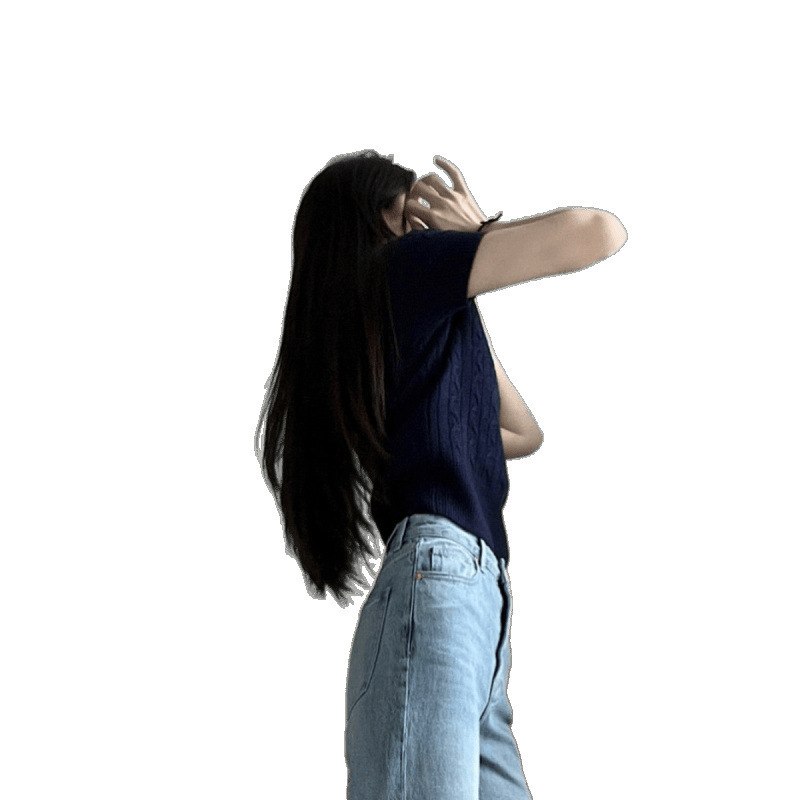 Person posing with arm raised, wearing jeans.