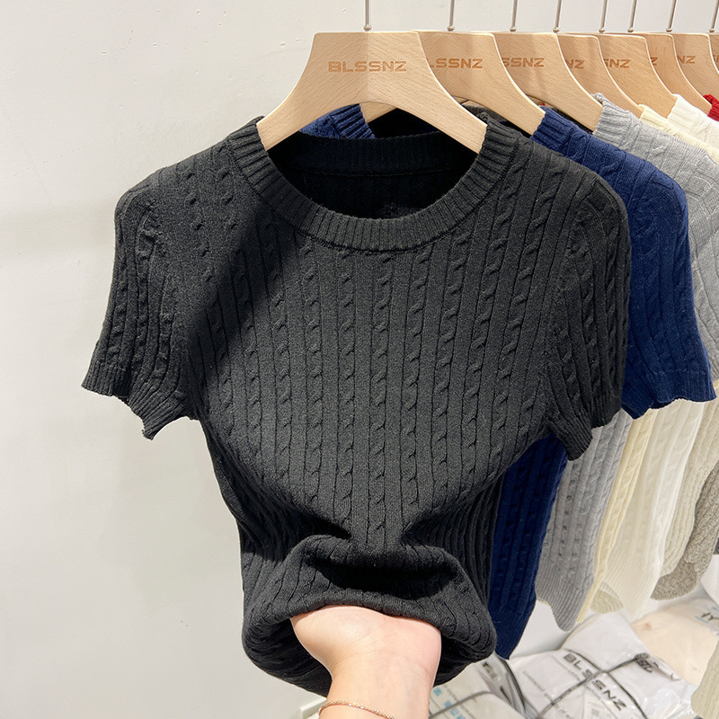 Black knit sweater on wooden hanger display.