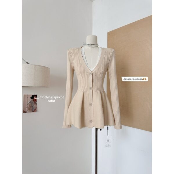Apricot cardigan on mannequin in room.