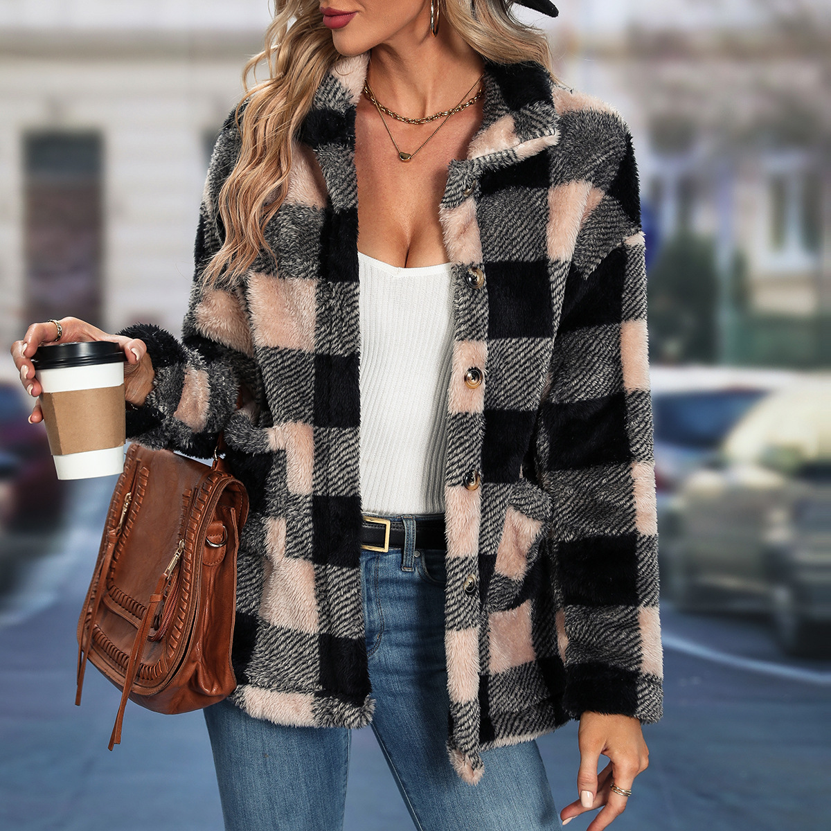 Woman in plaid coat holding coffee cup.