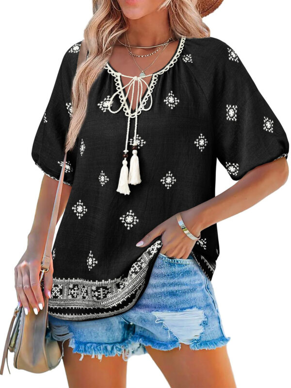 Woman in black embroidered blouse and shorts.