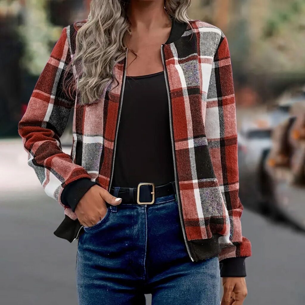 Woman wearing red plaid jacket outdoors.