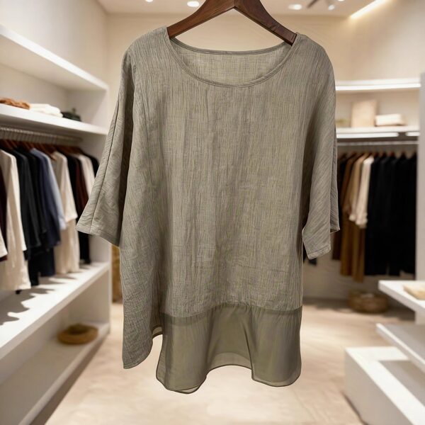 Gray tunic displayed in modern boutique.