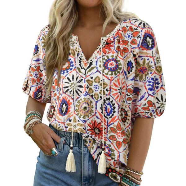 Woman wearing colorful patterned blouse and jeans.