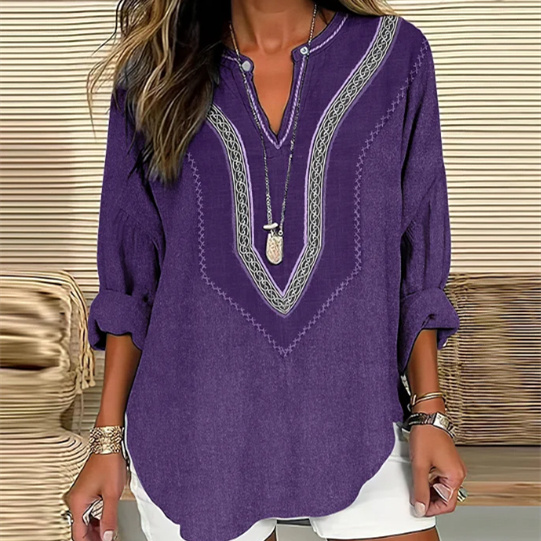 Woman wearing purple blouse and white shorts.