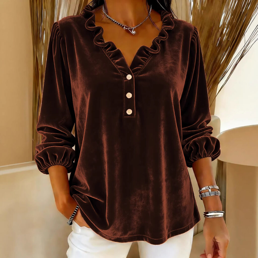 Woman wearing brown velvet blouse indoors.