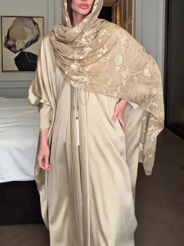Woman in elegant beige abaya and hijab.