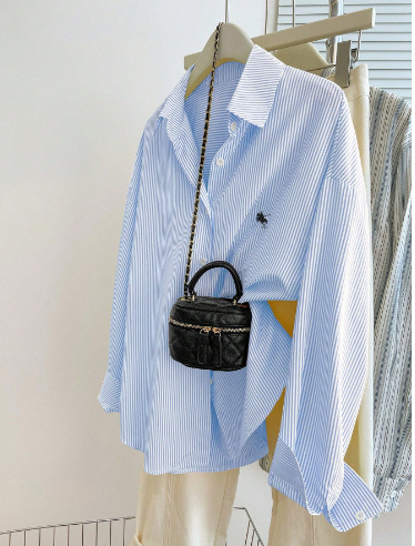 Striped shirt with small black handbag.