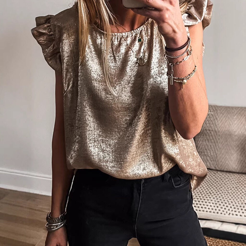 Woman wearing shiny gold top indoors.