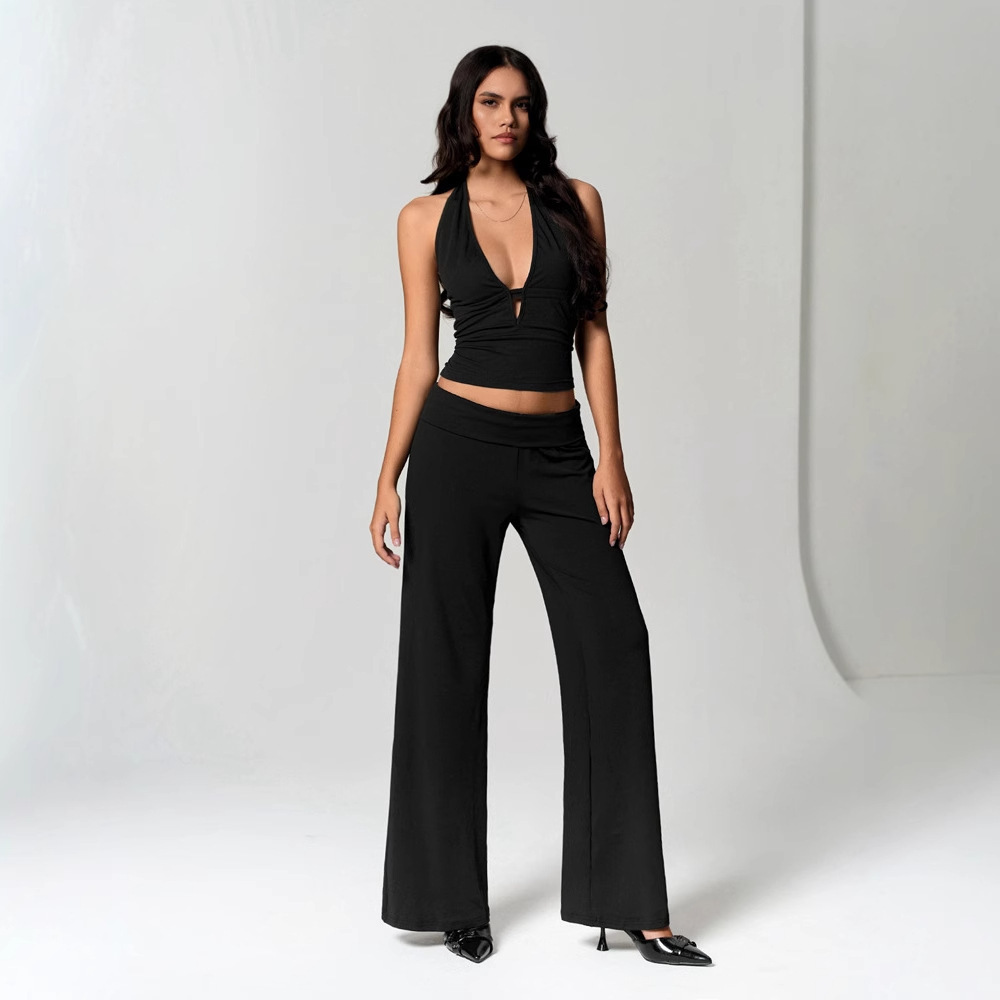 Woman in black outfit posing confidently.
