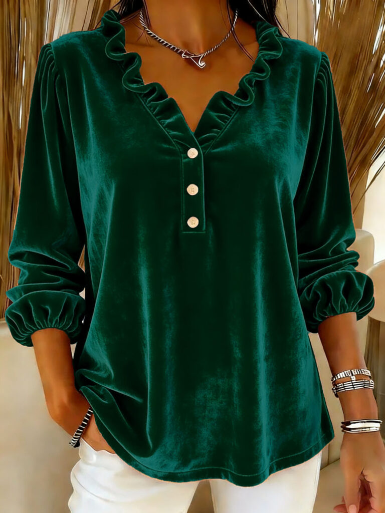 Woman in green velvet blouse, white pants.