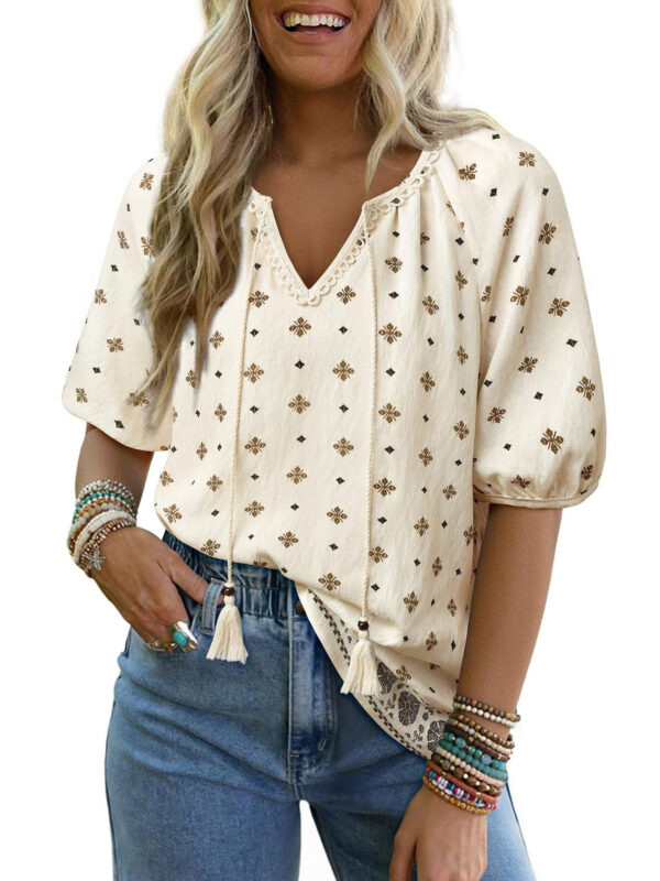 Woman in embroidered blouse and jeans smiling.