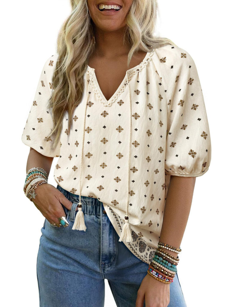 Woman in embroidered blouse and jeans smiling.