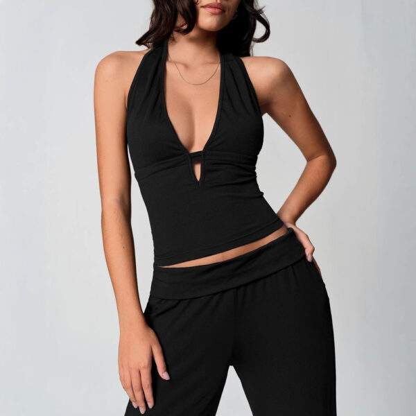 Woman wearing black sleeveless outfit posing.