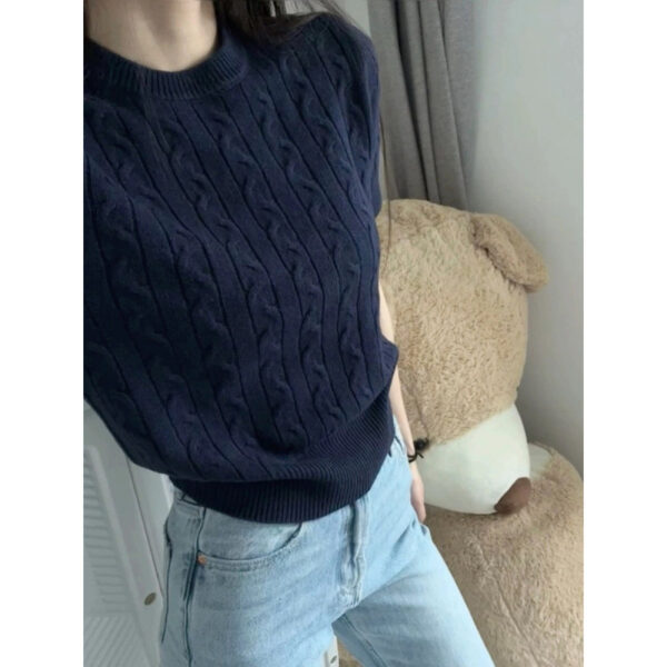 Person wearing blue sweater and jeans indoors.