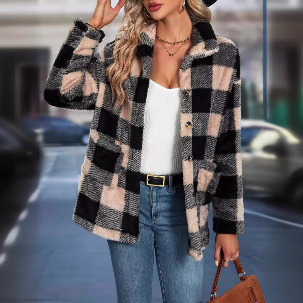 Woman in plaid jacket poses stylishly outside.