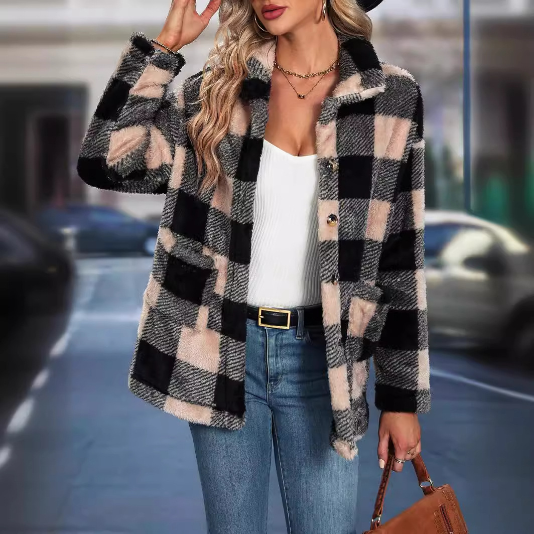 Woman in plaid jacket poses stylishly outside.
