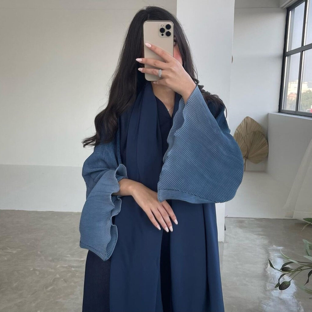 Person in blue attire taking a selfie.