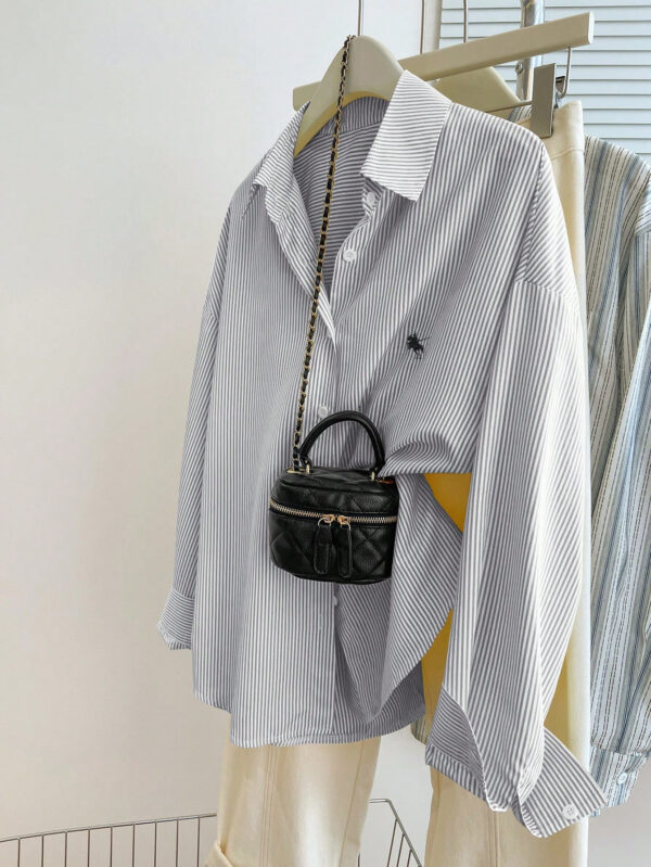 Striped shirt with small black purse attached.