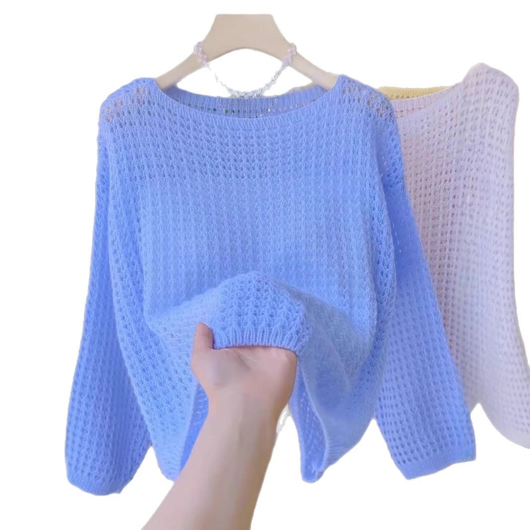 Hand holding light blue knitted sweater.