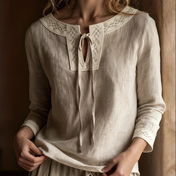 Woman wearing a beige lace-trimmed blouse.