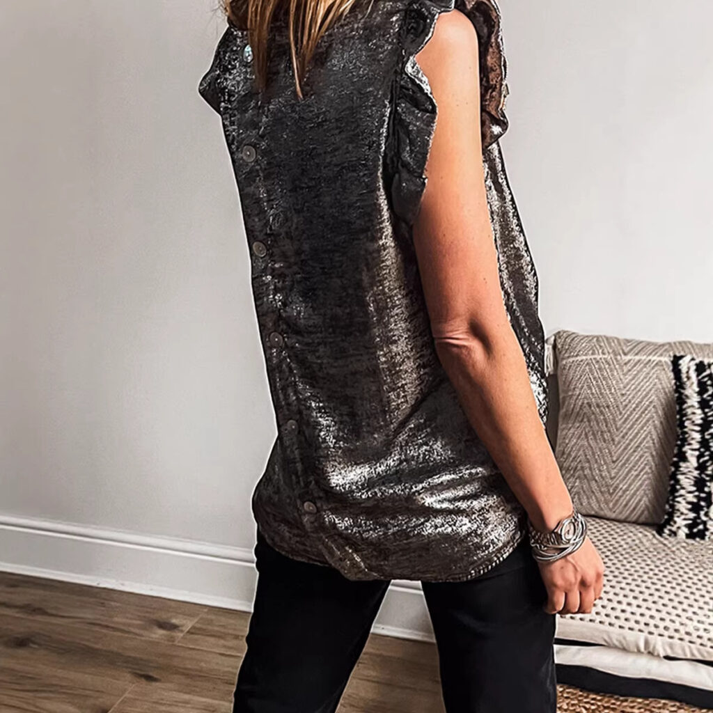 Woman wearing a sleeveless metallic top.