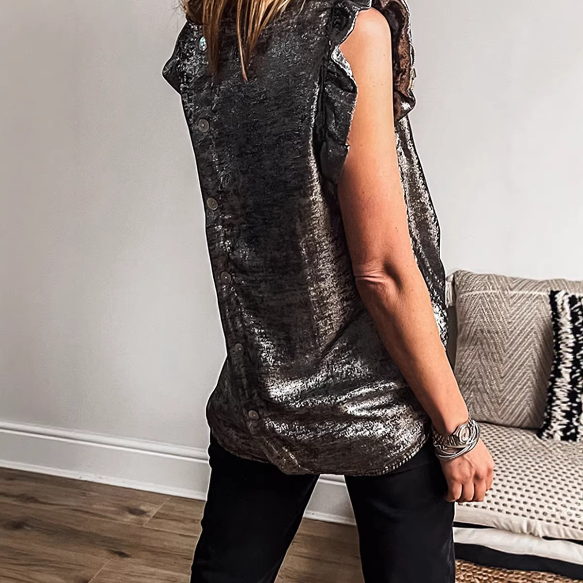 Woman wearing a sleeveless metallic top.