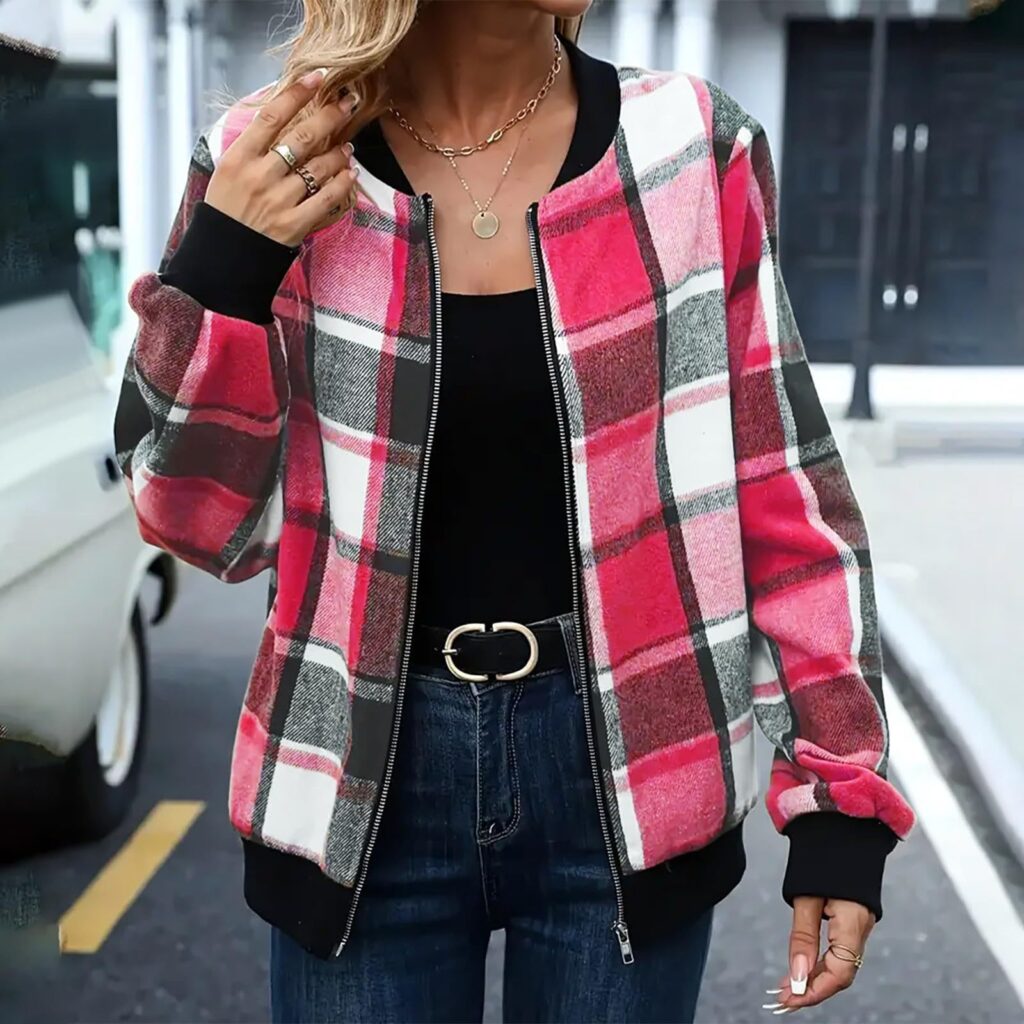 Woman wearing pink plaid jacket outside.