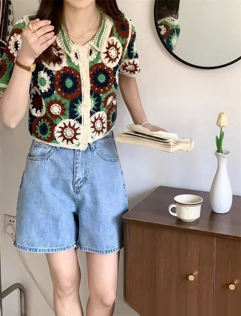 Woman in floral top with books and coffee.