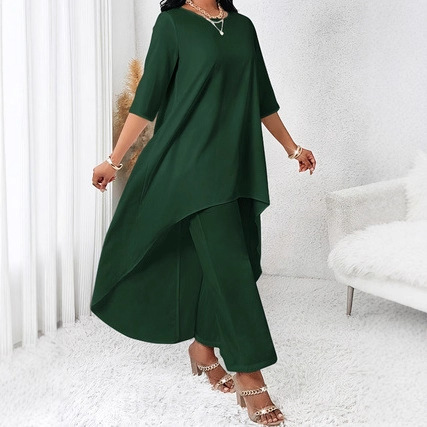 Woman in green asymmetrical outfit indoors.
