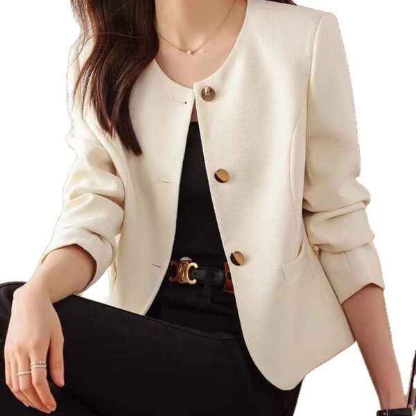 Woman wearing stylish cream blazer, black outfit.