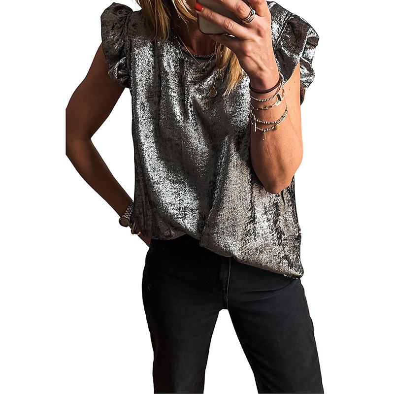 Person wearing metallic silver blouse, black pants.