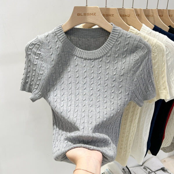 Gray knit sweater on wooden hanger display.