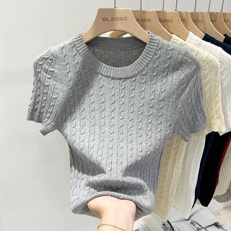 Gray knit sweater displayed on wooden hanger.