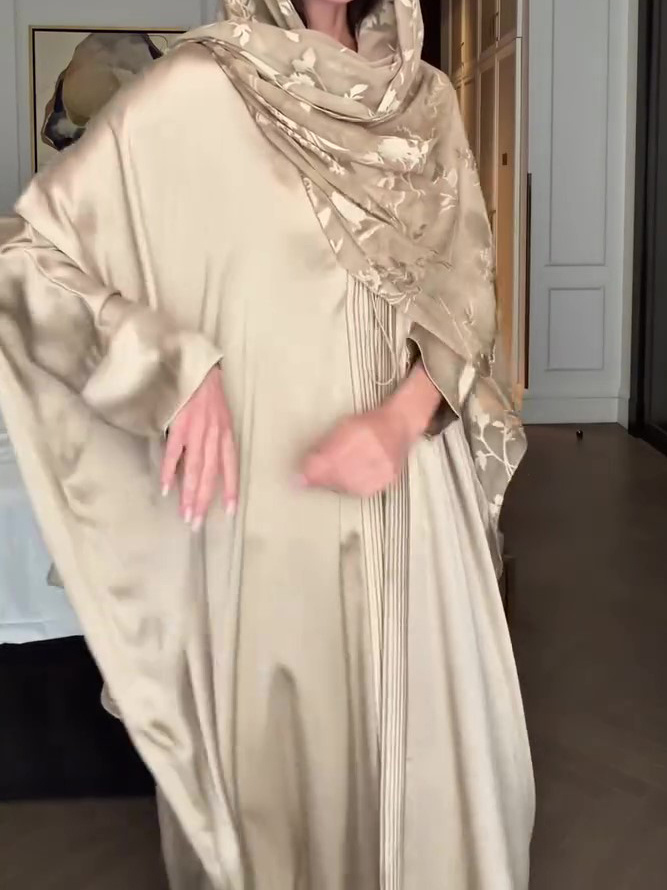 Person wearing elegant beige satin abaya.