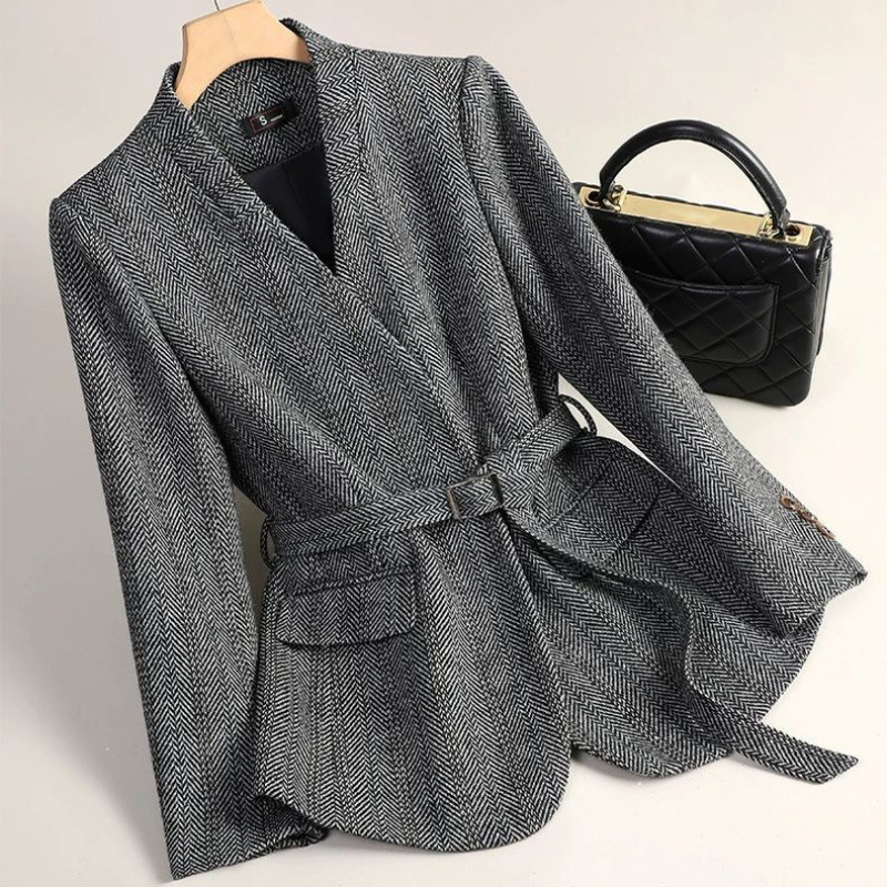 Gray herringbone blazer with black handbag.