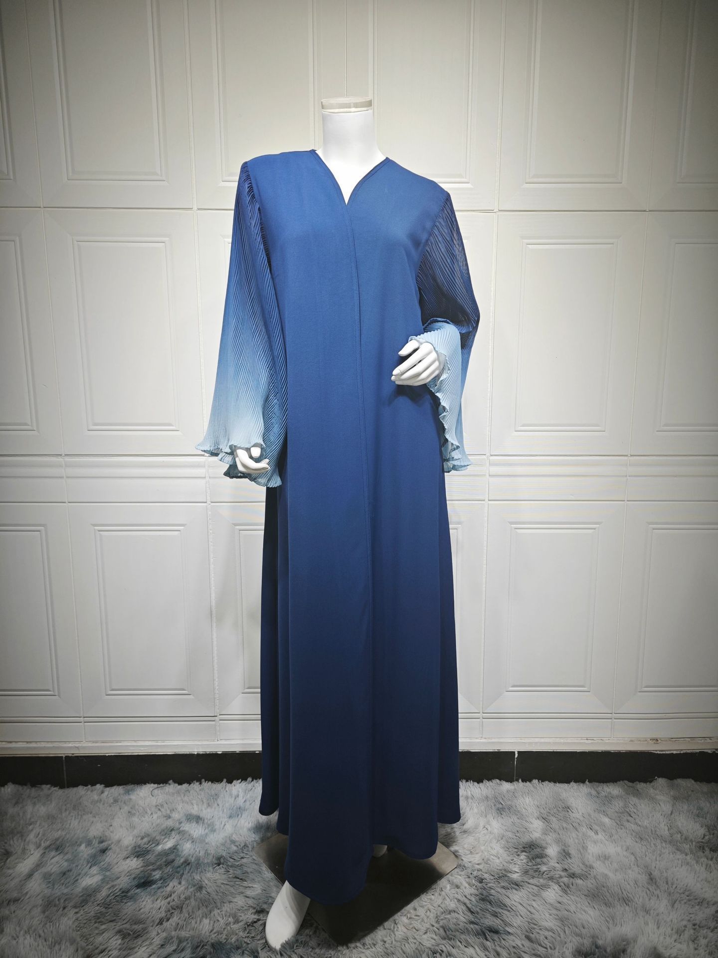 Blue dress on mannequin in white room.