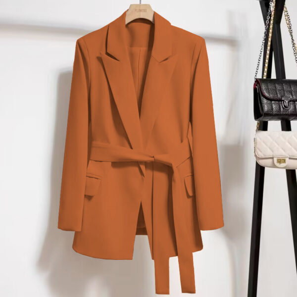 Orange blazer on hanger with purses.