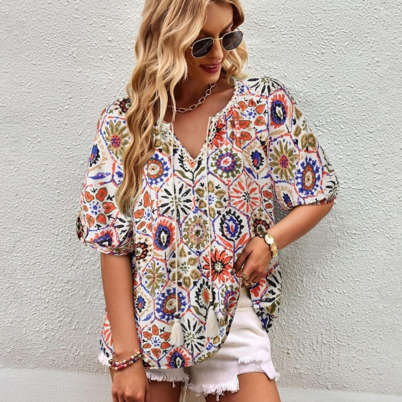 Woman in colorful floral blouse, sunglasses.