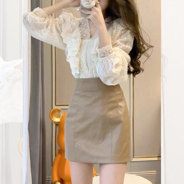 Woman in lace blouse and beige skirt.