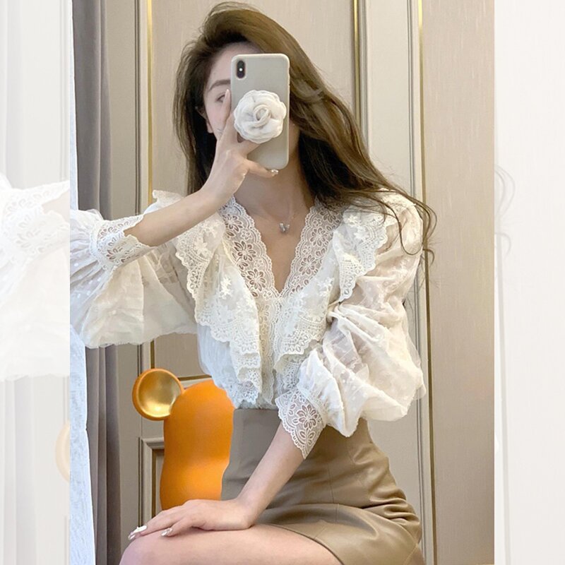 Woman taking selfie in elegant lace blouse.