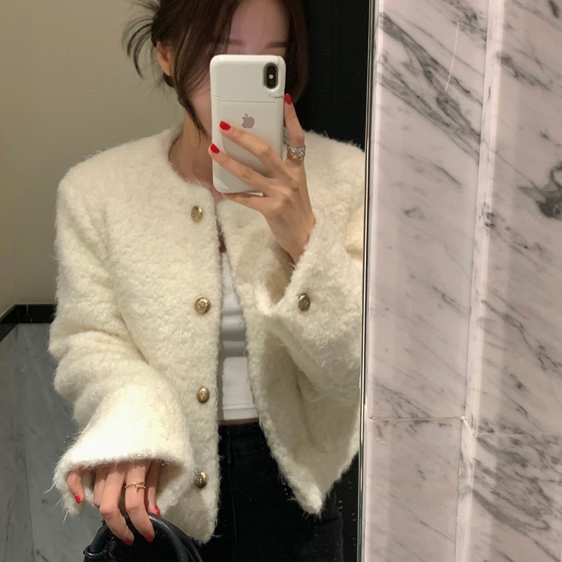 Person taking a mirror selfie wearing a fluffy white jacket.