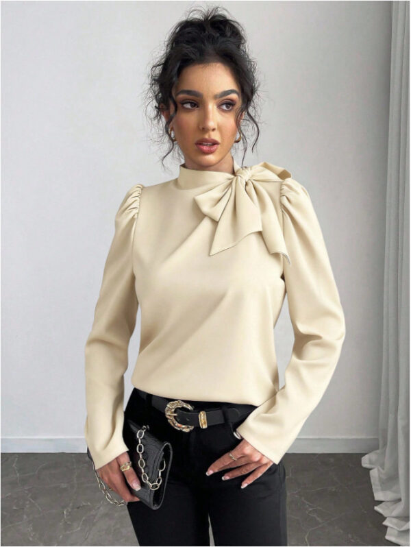 Woman in beige blouse with bow.