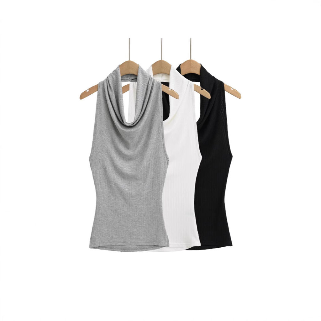 Three sleeveless tops on wooden hangers.